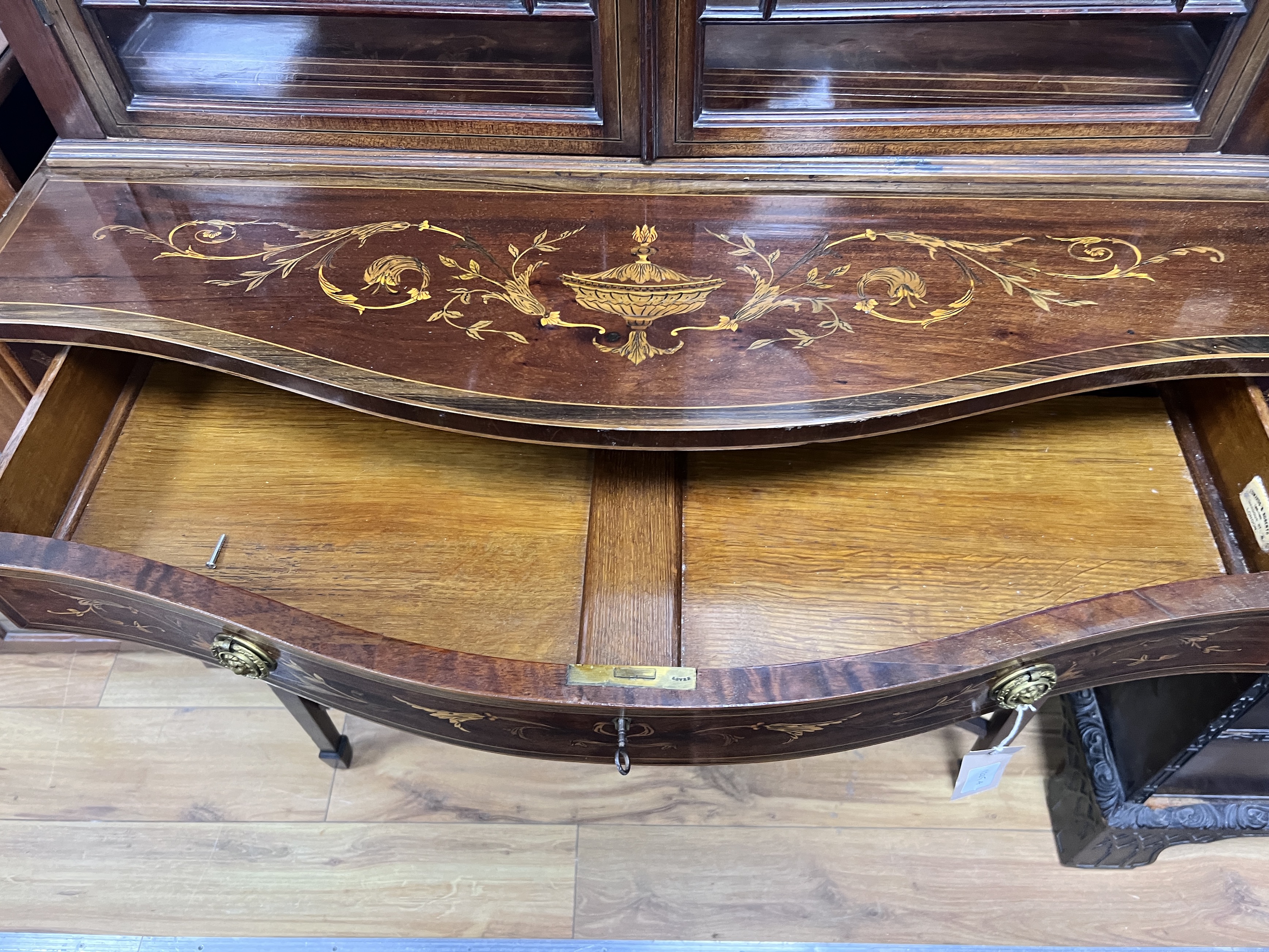 An Edwardian marquetry inlaid mahogany serpentine display cabinet, (bears Edwards & Roberts ivorine plaque), width 92cm, depth 50cm, height 208cm